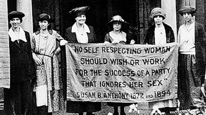 A group of suffragettes protesting for women's rights with a banner about parties discriminating aga...