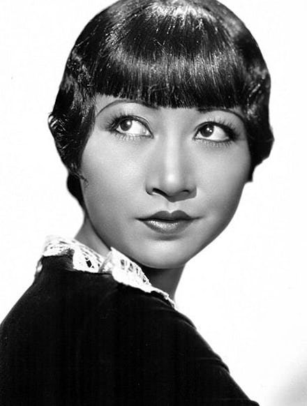 Back and white picture of an Asian woman in black looking upwards