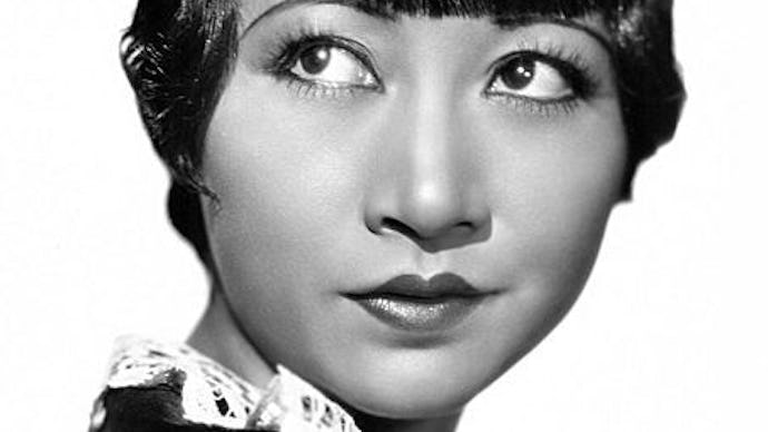 Back and white picture of an Asian woman in black looking upwards