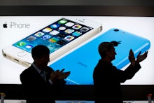Two man applauding in front of a screen with a white and blue iPhone