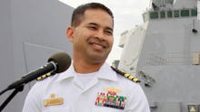 Commander Michael Misiewicz giving a speech in a white uniform