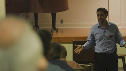 A man holding a lecture on what happens to people in America who can't afford Internet access