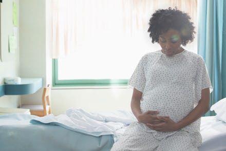 A pregnant woman sitting on a hospital bed