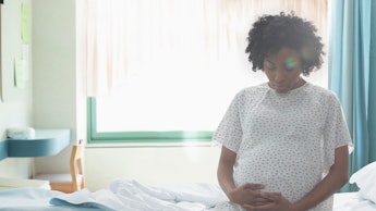 A pregnant woman sitting on a hospital bed 