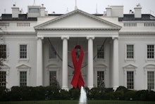 The White House with a red ribbon on it representing AIDS awareness