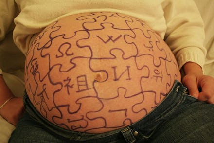 A pregnant belly and puzzles drawn on it