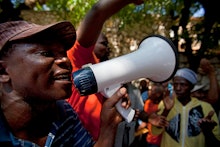 People with megaphones protesting in front of a dominican court