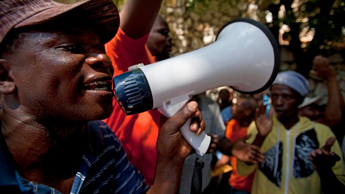 People with megaphones protesting in front of a dominican court