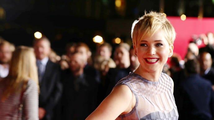 Jennifer Lawrence in a sleeveless grey dress and short haircut at a red carpet