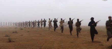 Al-Qaeda in Iraq marching through the desert with rifles in their arms