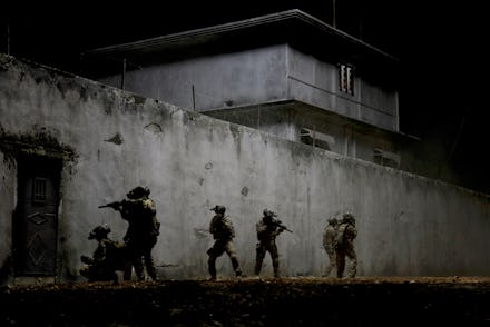 A screenshot with solider walking around a building from the movie 'Iraq in Fragments'