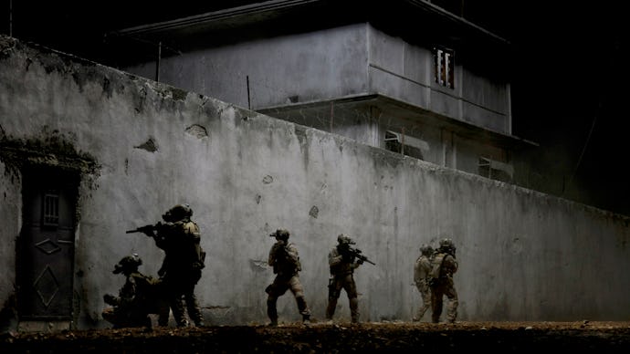 A screenshot with solider walking around a building from the movie 'Iraq in Fragments'