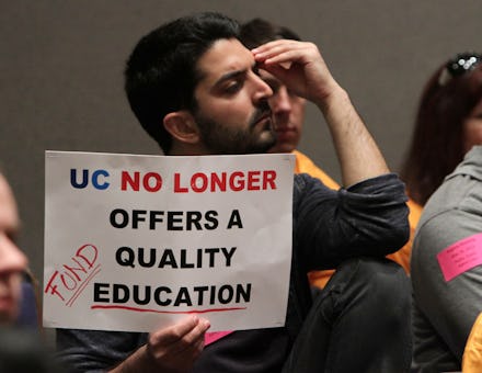A student holding a sign that says "UC no longer offers a quality education"