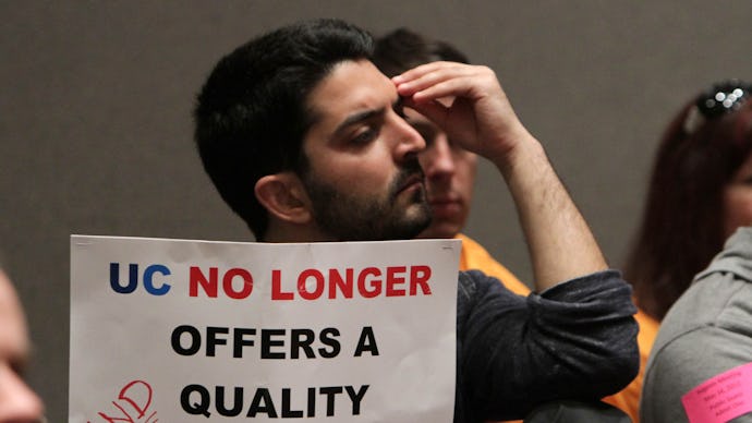 A student holding a sign that says "UC no longer offers a quality education"