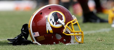 Washington Redskins helmet, with a Native American character on it, laying on the football field.