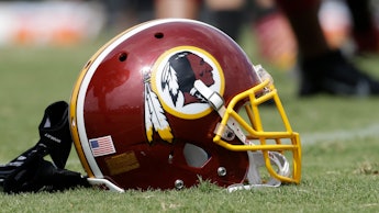 Washington Redskins helmet, with a Native American character on it, laying on the football field.
