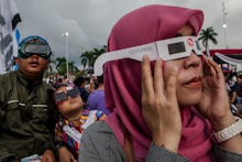 A group of people wearing glasses during a solar eclipse