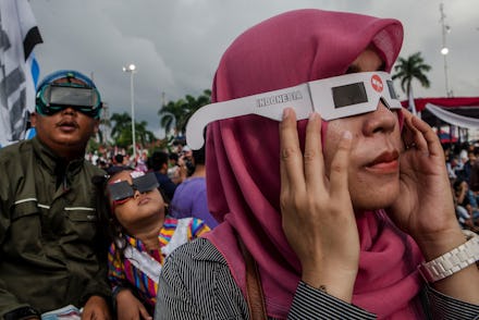 A group of people wearing glasses during a solar eclipse