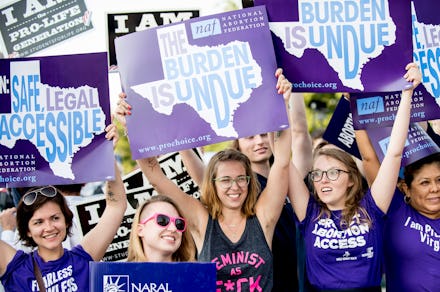 A group protesting texas abortion legislation holding up signs