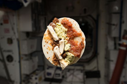 A burrito flying in the air at a space station