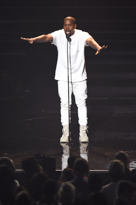 Kanye West performing live on stage wearing an all white outfit