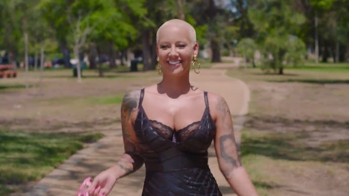 Amber Rose smiling in a black lace top while walking