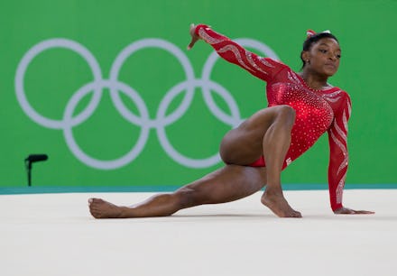 Simone Biles, Rio's Olympics gymnastics favorite, leaning on her hand while posing in a red suit