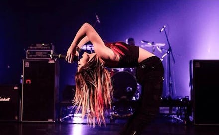 Young blonde singer tilting her back backwards while singing