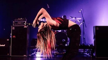Young blonde singer tilting her back backwards while singing
