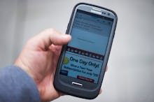 A man holding a smart phone that he bought as part of a cyber monday scam