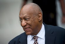 Bill Cosby walking in a formal suit