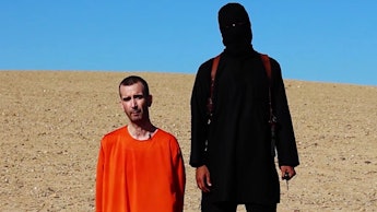 Islamic State's soldier dressed fully in black standing next to a hostage