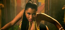 Nicki Minaj crawling on the floor in a gold bra and ponytail in her music video