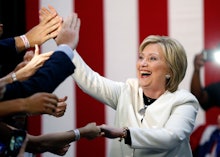 Hillary Clinton laughing and shaking hands at a political rally
