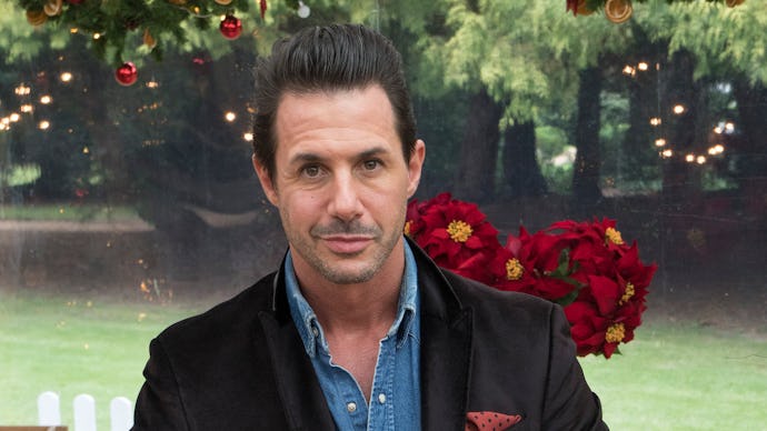 Johnny Iuzzini sitting on a table in a black blazer and a blue button up shirt