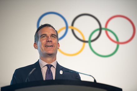 Eric Michael Garcetti, a former Los Angeles mayor, giving a speech with Olympic rings in his backgro...