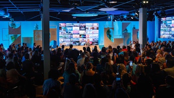 People at a conference listening to Mark Zuckerberg delivering a speech