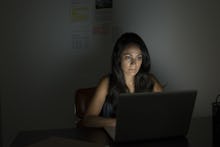 Woman using laptop in the dark room