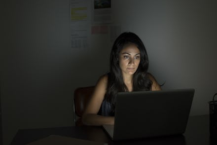 Woman using laptop in the dark room
