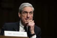  Robert Mueller sitting at a table with his name tag in front of him, looking focused