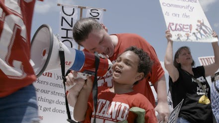 A boy holding a megaphone on the protest for increasing the minimum wage