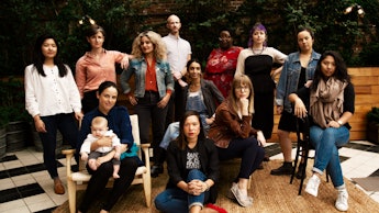 Group of women that are working in restaurants posing for a photo in front of a restaurant