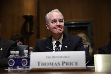 Thomas Price sitting behind a white cardboard sign that says his name on it