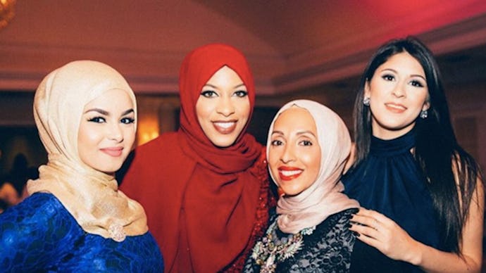 Four Muslim women in formal dresses, also wearing hijabs 