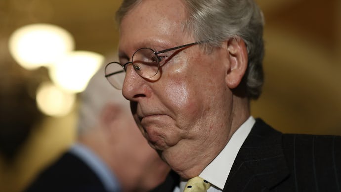 Mitch McConnell wearing a formal suit and eyeglasses