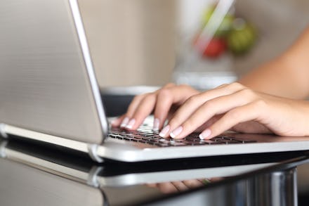Closeup of a woman's hands typing on her laptop, while she stalks her boyfriend online