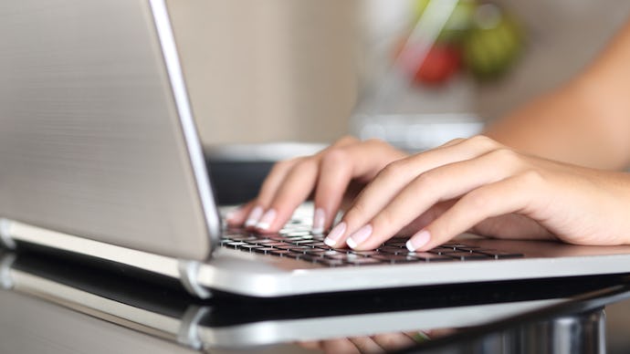 Closeup of a woman's hands typing on her laptop, while she stalks her boyfriend online