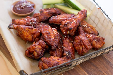 Dark chicken wings served in a box with barbecue sauce