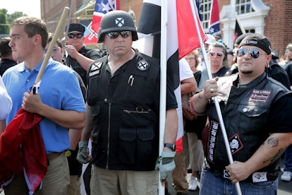 A group of demonstrators wearing black clothes and helmets and flags