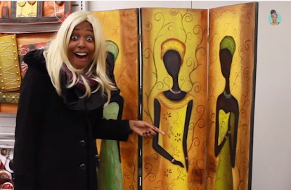  Blogger Chescaleigh points toward an artwork of a black woman in African cultural clothes